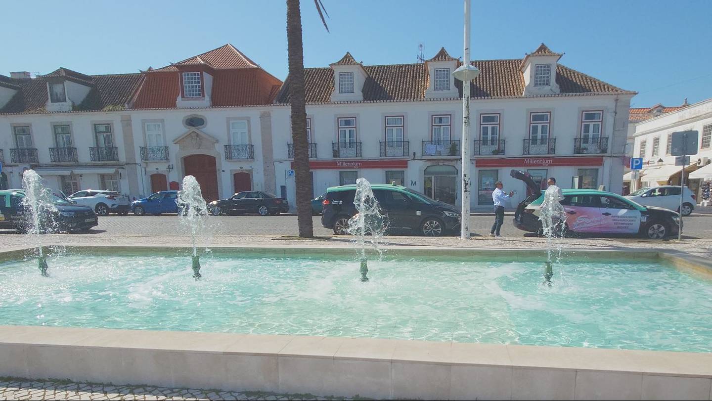 Fountain on the waterfront with buildings in the background