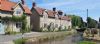 Limestone cottages with red pan tile roof along the side of a Brookside at Hovingham - motorcbike tour Yorkshire and Lake District